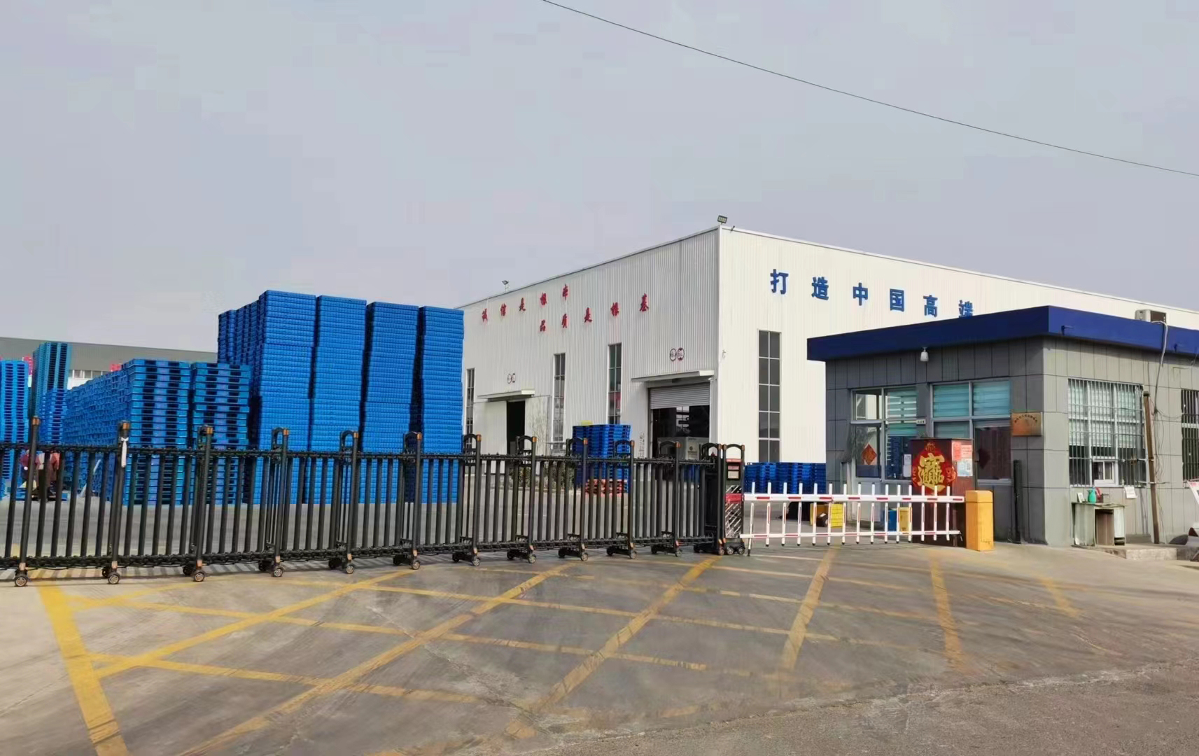 Rulyda Plastic's heavy-duty plastic pallet manufacturing facility in Qingdao, China, featuring large stacks of blue industrial pallets ready for global shipment